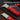 Red utility knife with thickened zinc alloy blade on a laptop