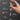 Hand holding a screwdriver with labeled features on a dark background
