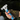 Multifunctional tool with a long handle held by a person wearing gloves.