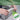 Person using a level/ruler on a concrete block with a green background