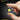 Small portable light held between fingers with text highlighting its weight and portability.