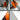 Close-up of a blade sharpening tool featuring a rotating grinding wheel and an orange protective housing. Designed for precise edge sharpening on knives, chisels, and cutting tools