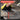 A hand uses a yellow and black foam sanding sponge to sand a dark metal surface, with a red 'CHARACTERISTICS' banner at the top and a feature checklist overlay at the bottom right.