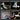 Multitool with various tools including a hammer, screwdriver, wire cutter, and knife on a black background.