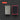 A 60 grit sharpening kit shown in two pieces: a rectangular metal rod with a textured geometric pattern on one side, and a rectangular black abrasive pad with a red border on the other. The background is a dark gray with concentric circle patterns, and a red label in the top left corner reads 'KIT 60 GRIT'.