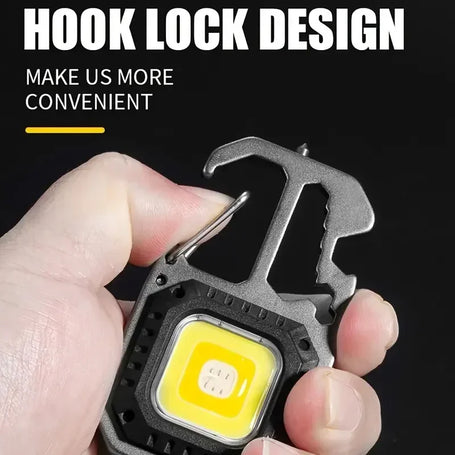Hand holding a multi-tool with LED light, featuring a hook lock design on a black background.