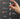 Hand holding a screwdriver with labeled features on a dark background