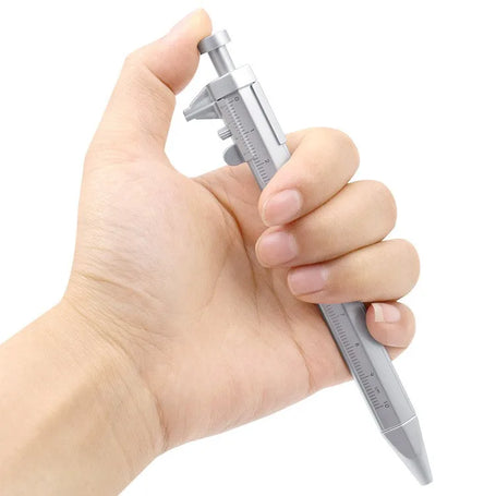 Hand holding a small metallic caliper against a white background