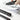 Hand using a paper utility knife on printed documents.